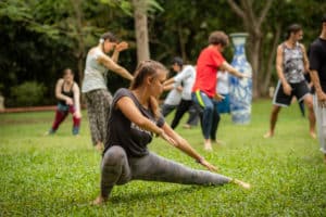 barefoot woman practicing qigong bear outside on grass 