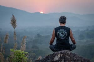 man meditating sunrise