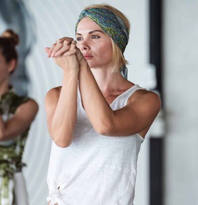 Disadvantages of Qigong. A woman in white sando practicing qigong during a qigong class.